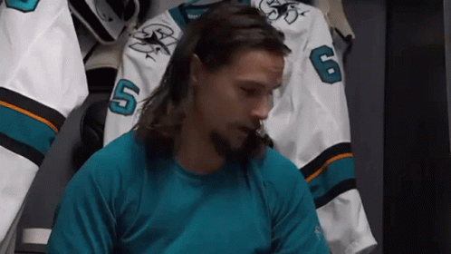 Bearded Long-Haired Man in Locker Room with Hockey Jersey