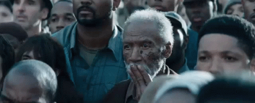 Bearded Man Covering Mouth In Crowd GIF