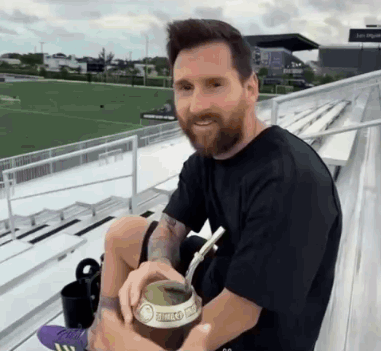 Bearded Man Drinking with Straw on Bleacher
