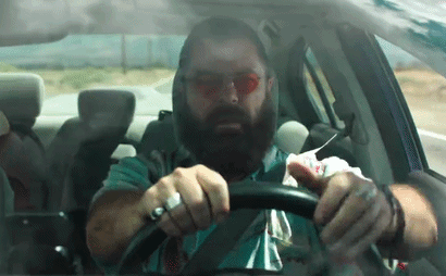 Bearded Man Driving Car With Napkin On Face