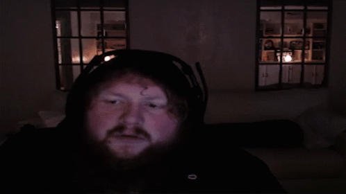 Bearded Man Headphones Looking At Camera Dark Room GIF