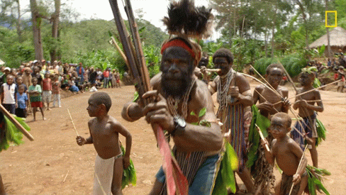 Bearded Man Holding Spear In Front Of Crowd GIF