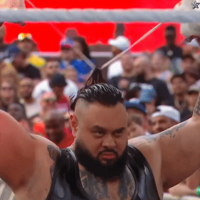 Bearded Man Holding Stick in Front of Crowd
