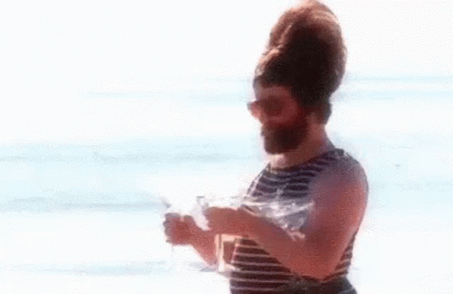 Bearded Man Holding Two Wine Glasses on Beach