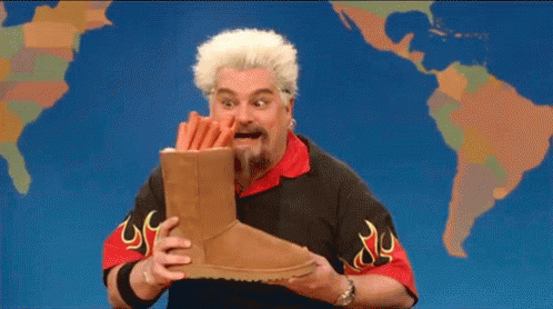 Bearded Man Holding Ugg Boots In Front Of World Map GIF