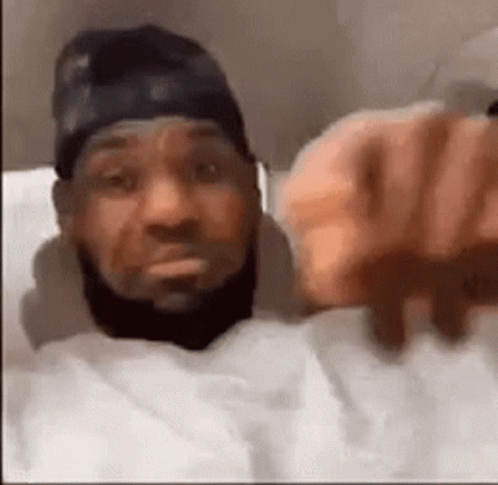 Bearded Man in Bed Pointing