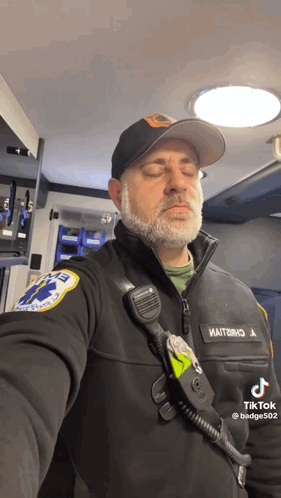Bearded Man in Black Jacket and Hat with EMT Patch