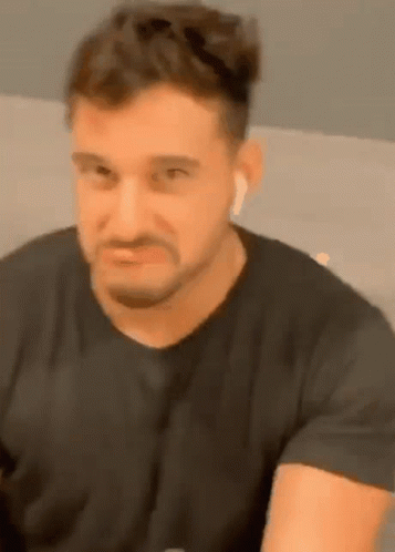 Bearded Man In Black Shirt And Ear Buds GIF