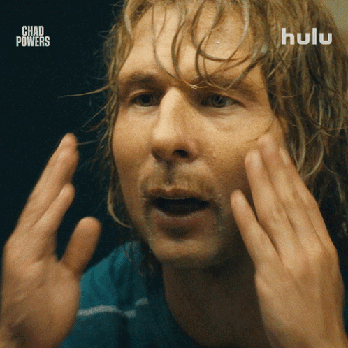 Bearded Man in Blue Shirt and Black Vest Saying Hulu
