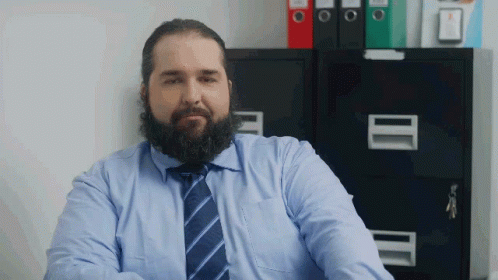 Bearded Man In Blue Shirt And Tie At Filing Cabinet GIF
