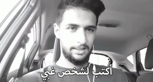 Bearded Man in Car With Arabic Writing on Face