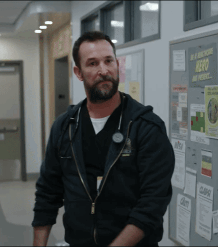 Bearded Man in Front of Hero and Present Bulletin Board