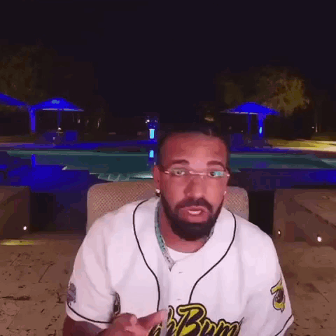 Bearded Man in Glasses Sitting by Pool at Night
