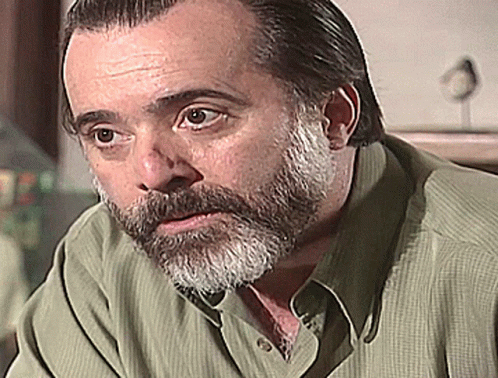 Bearded Man in Green Shirt Looking at Camera