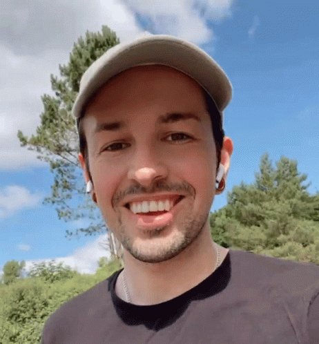 Bearded Man in Hat and Earbuds Smiling