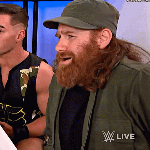 Bearded Man in Hat and Jacket Saying W Live