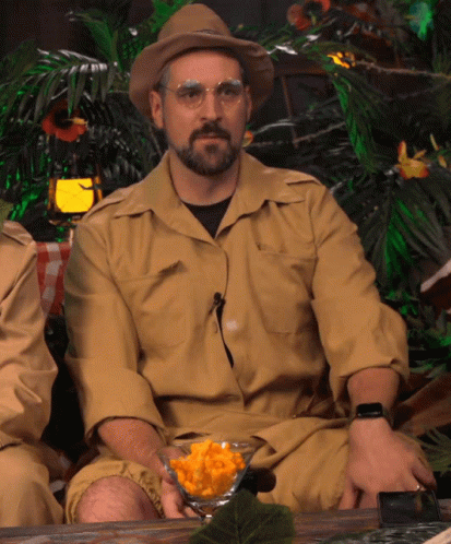 Bearded Man in Hat, Glasses Holding Food Bowl