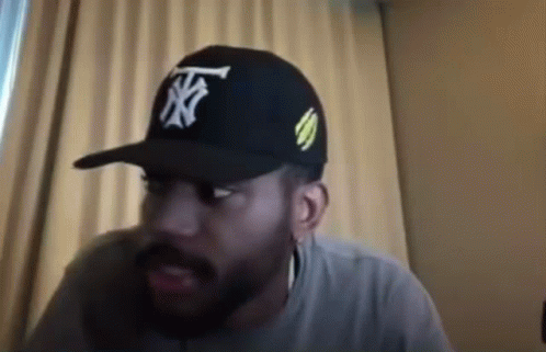 Bearded Man in Hat Sitting by Window