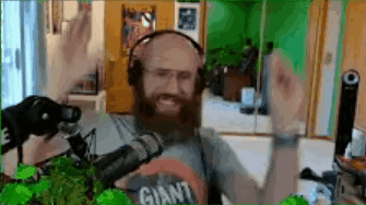 Bearded Man in Headphones Wearing Giant Shirt at Microphone