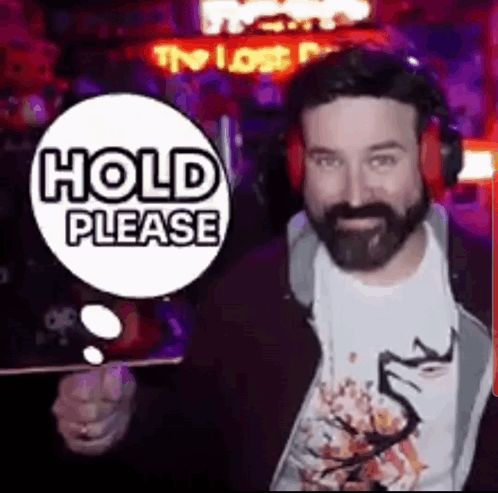 Bearded Man in Headphones with Hold Please Sign