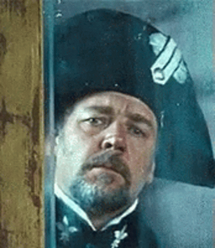 Bearded Man in Napoleonic Hat Looking Out Window