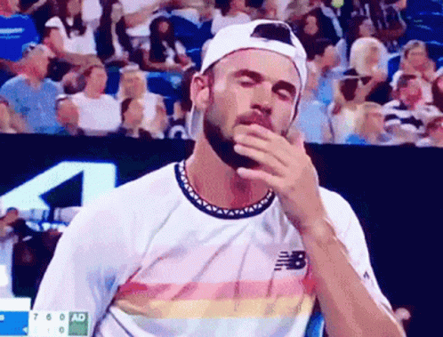 Bearded Man in New Balance Shirt Wiping Face