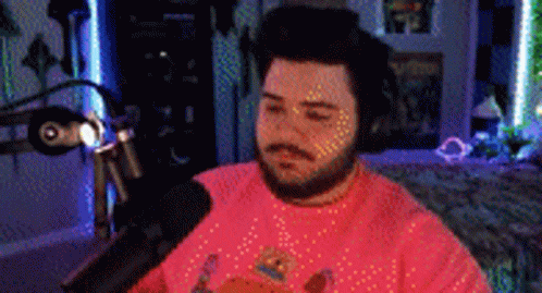 Bearded Man in Pink Shirt at Microphone