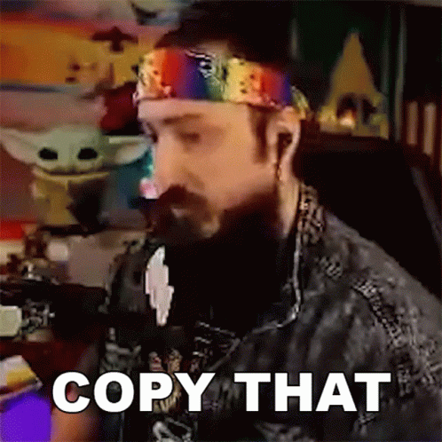 Bearded Man in Rainbow Headband at Computer Saying Copy That