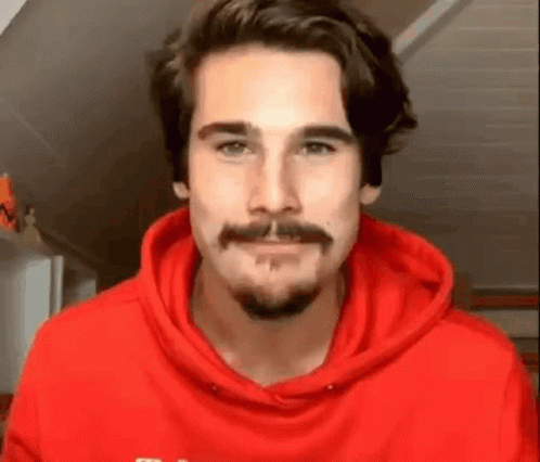 Bearded Man In Red Hoodie Looking At Camera GIF
