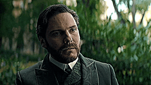 Bearded Man in Suit and Tie in Front of Trees