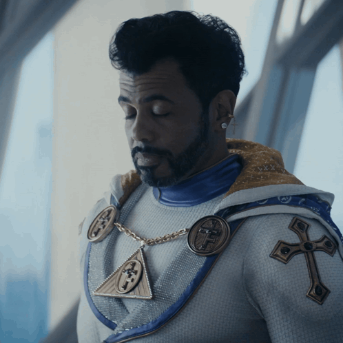 Bearded Man in White and Blue Outfit with Cross