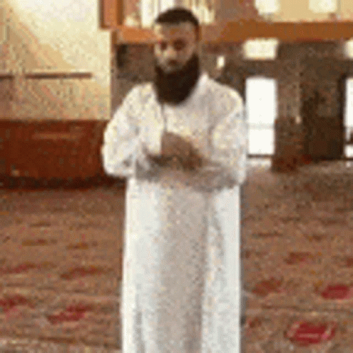 Bearded Man in White Robe Praying at Mosque