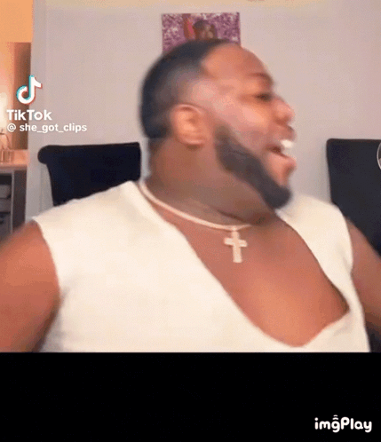 Bearded Man In White Tank Top And Cross Necklace GIF