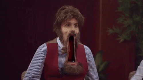 Bearded Man In Wig With Mouth Wide Open At Table GIF