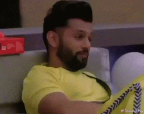 Bearded Man In Yellow Shirt Sitting On Couch GIF