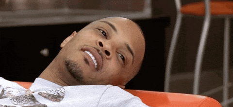 Bearded Man Laying on Red Couch Smiling