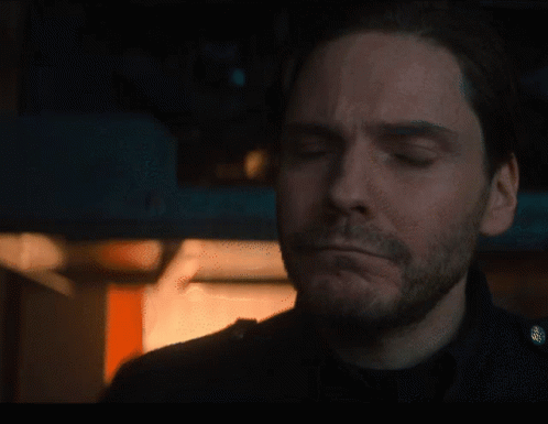 Bearded Man Looking At Camera In Dark Room GIF