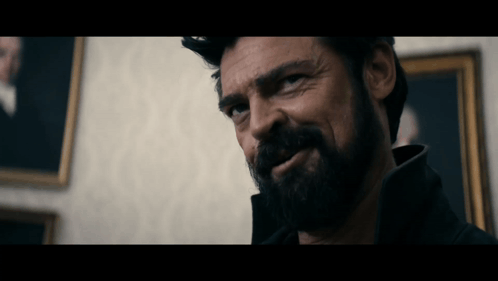 Bearded Man Looking at Camera in Front of Painting