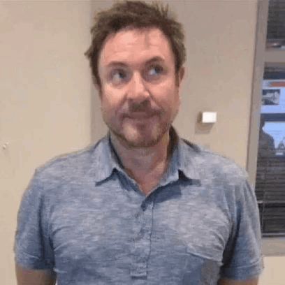 Bearded Man Making Funny Face in Blue Shirt