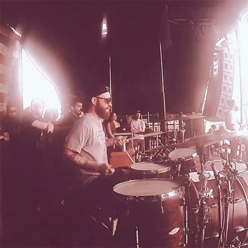 Bearded Man Playing Drums for Crowd