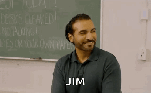 Bearded Man Sitting at Blackboard