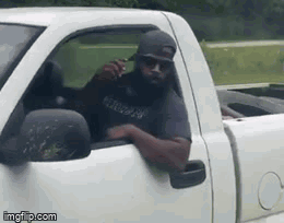 Bearded Man Sitting in White Truck Talking on Cell Phone
