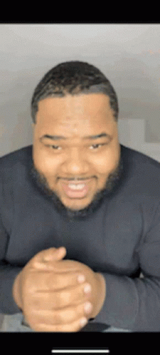 Bearded Man Smiling with Hands Folded