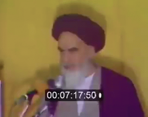 Bearded Man Speaking at Microphone With Timer