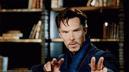 Bearded Man Standing At Bookshelf GIF