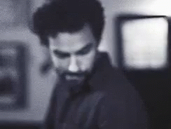 Bearded Man Standing in Dark Room