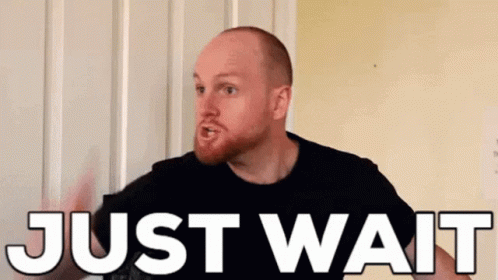 Bearded Man Standing in Front of Door Saying Just Wait