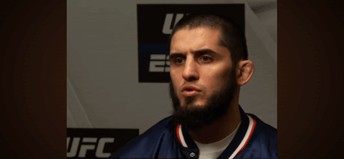 Bearded Man Standing In Front Of UFC Sign GIF
