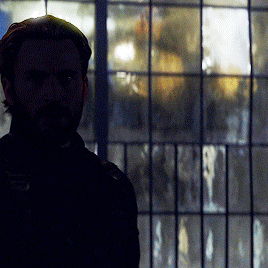 Bearded Man Standing in Front of Window With Reflection