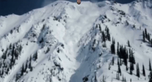 Bearded Man Standing On Snowy Mountain GIF